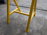Yellow metal trestle on a concrete floor.